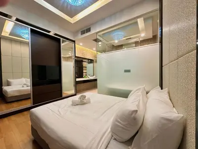 a bedroom with a white bed and a large mirror at Dorsett Bukit Bintang with Bathtub by Prestige in Kuala Lumpur