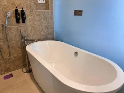 a white bath tub in a bathroom with a blue wall at Dorsett Bukit Bintang with Bathtub by Prestige in Kuala Lumpur