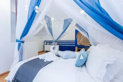 a bedroom with a white bed with blue curtains at EkoCheras max5pax Romance Retreats #freeparking #netflix #wifi in Kuala Lumpur