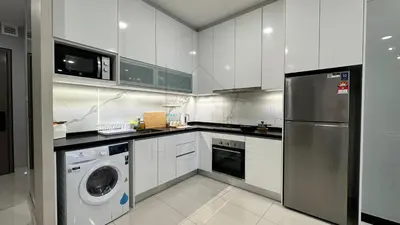 a kitchen with white cabinets and a washer and dryer at Societe Suites 108 Hartamas Mont Kiara Kuala Lumpur 2-6pax in Kuala Lumpur