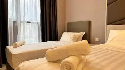 a hotel room with two beds and a window at Societe Suites 108 Hartamas Mont Kiara Kuala Lumpur 2-6pax in Kuala Lumpur