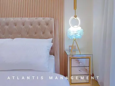 a bedroom with a bed and a night stand with a lamp at Arte Mont Kiara in Kuala Lumpur