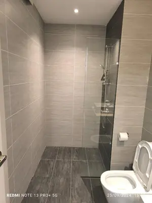 a bathroom with a toilet and a glass shower at Trion by sweet home in Kuala Lumpur