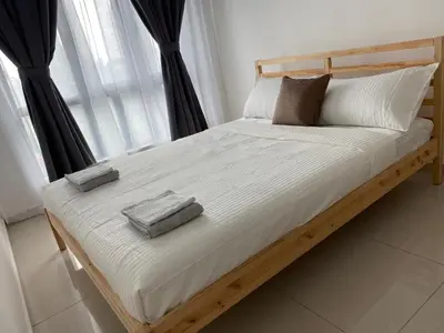a bed with two pillows on it in front of a window at KLCC Skyhomes near LRT in Kuala Lumpur