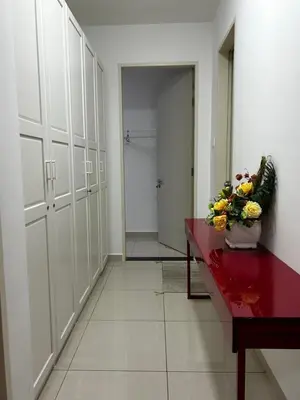 a hallway with white lockers and a vase of flowers at KLCC Skyhomes near LRT in Kuala Lumpur