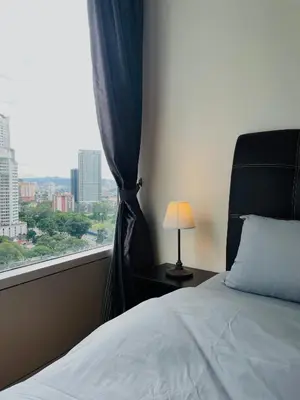 a bedroom with a window with a bed and a lamp at Vortex Hotel Suites & Residence by KLCC in Kuala Lumpur