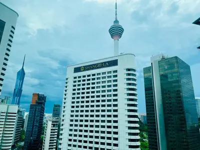 a tall building with the cologne needle in the city at Vortex Hotel Suites & Residence by KLCC in Kuala Lumpur