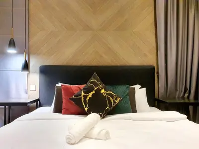 a stuffed animal is laying on a bed at The Mews KLCC by GBS in Kuala Lumpur