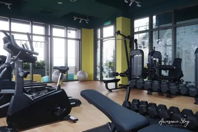 a gym with treadmills and exercise equipment and windows at Awesomestay apartment walk to Tun Sambathan near KL Sentral in Kuala Lumpur