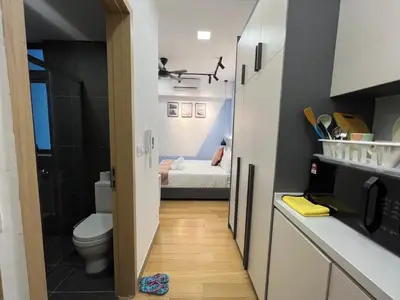 a small bathroom with a toilet and a bedroom at The Colony By Infinitum KLCC in Kuala Lumpur
