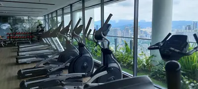 a gym with a row of exercise bikes in front of a window at The Colony By Infinitum KLCC in Kuala Lumpur