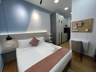 a bedroom with a bed and a table and a chair at The Colony By Infinitum KLCC in Kuala Lumpur