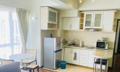 a kitchen with a refrigerator and a table with chairs at Homestay Room near KLCC in Kuala Lumpur