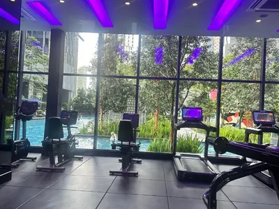 a gym with chairs and a pool in a building at Holiday Suites at Star in Kuala Lumpur