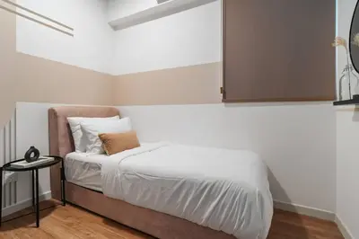 a bedroom with a bed with a cabinet on the wall at 4BR Modish Room MVertica Near MRT by RumaBnB in Kuala Lumpur
