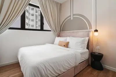 a bedroom with a large white bed with a window at 4BR Modish Room MVertica Near MRT by RumaBnB in Kuala Lumpur
