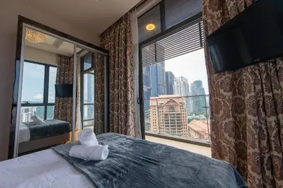 a bedroom with a large window and a bed with a towel at 1-6pax Dorsett KL 3mins to Pavilion Infinity Pool in Kuala Lumpur