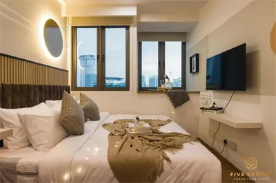 a bedroom with a bed with a tv and windows at Riveria Premium Kuala Lumpur, Roam in Kuala Lumpur