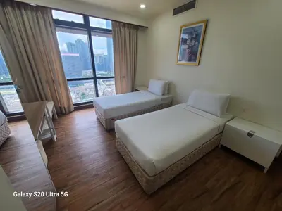 a hotel room with two beds and a large window at Premier CityView Times Square Apartment KL in Kuala Lumpur