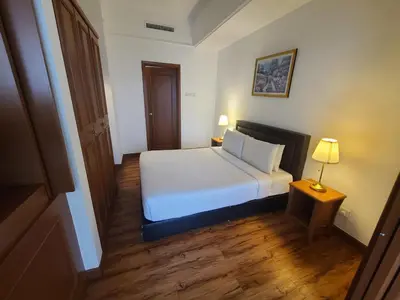 a bedroom with a white bed and a table and a lamp at Premier CityView Times Square Apartment KL in Kuala Lumpur