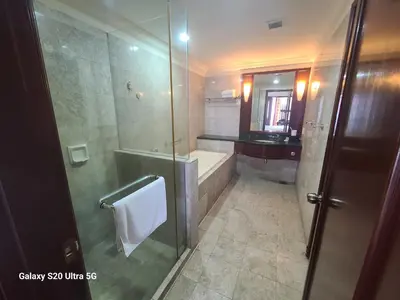 a bathroom with a shower and a tub and a sink at Premier CityView Times Square Apartment KL in Kuala Lumpur
