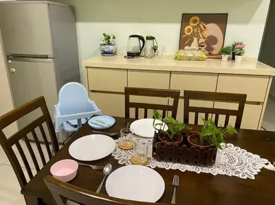 a dining room table with white plates and plants on it at Ampang 4-5 pax in Ampang Point in Ampang