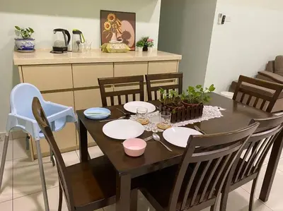a dining room table with chairs and a table with plates at Ampang 4-5 pax in Ampang Point in Ampang