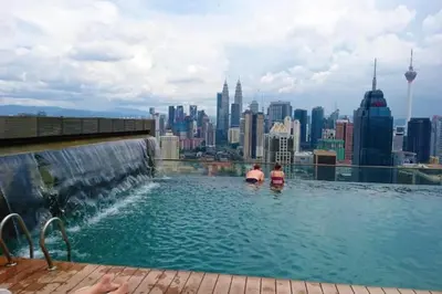two people in a infinity pool with a view of the city at 2br 2ba in the heart of KL, Regalia Residence in Kuala Lumpur