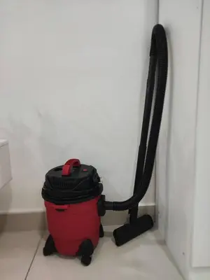 a red trash can sitting next to a wall at Vivo Soho Suites by Luvit Stay in Kuala Lumpur