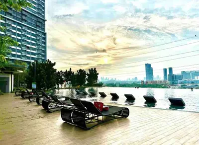 a row of lounge chairs next to a body of water at M Vertica By Seroja Coliving in Kuala Lumpur