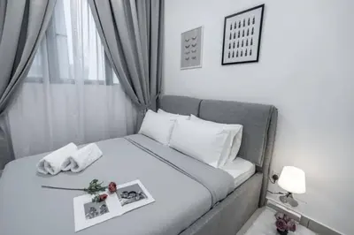 a small bedroom with a white bed with a tray on it at Trion KL -2BR, 2-5pax, near KLCC, KL Tower, IKEA, Velocity in Kuala Lumpur