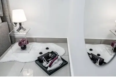 a mirror reflection of a room with a purse and flowers at Trion KL -2BR, 2-5pax, near KLCC, KL Tower, IKEA, Velocity in Kuala Lumpur