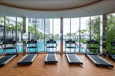 a gym with a row of treadmills next to a pool at Trion KL -2BR, 2-5pax, near KLCC, KL Tower, IKEA, Velocity in Kuala Lumpur