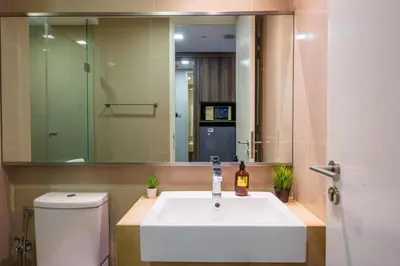 a bathroom with a sink and a toilet and a mirror at One Bukit Ceylon Bukit Bintang in Kuala Lumpur