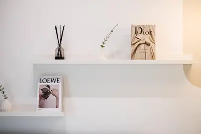 a white shelf with two pictures and a book at Bea Bea's Kidz Dreamland Mini Horse 4br 11pax MRT in Kuala Lumpur