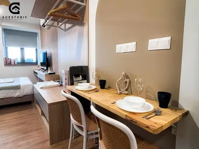 a room with a table with chairs and a bed at Riveria City KL Sentral by Guestonic in Kuala Lumpur
