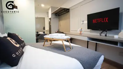 a hotel room with a bed and a tv on a desk at Riveria City KL Sentral by Guestonic in Kuala Lumpur