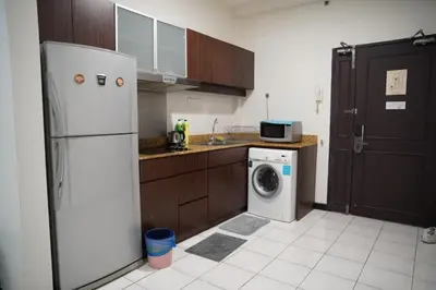 a kitchen with a refrigerator and a washing machine at The Luxe Apartment 2 Bedrooms in Kuala Lumpur