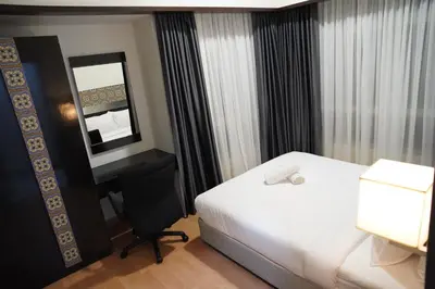 a hotel room with a bed and a desk and a mirror at The Luxe Apartment 2 Bedrooms in Kuala Lumpur
