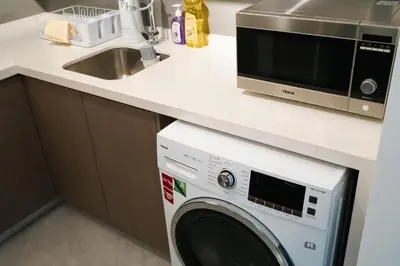 a kitchen with a microwave and a washing machine at Agile Bukit Bintang in Kuala Lumpur