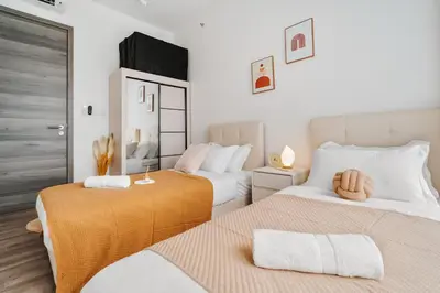 two beds in a room with white and orange at Agile Bukit Bintang in Kuala Lumpur