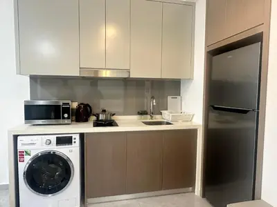 a kitchen with a washing machine and a microwave at Agile Premier Suites KL in Kuala Lumpur
