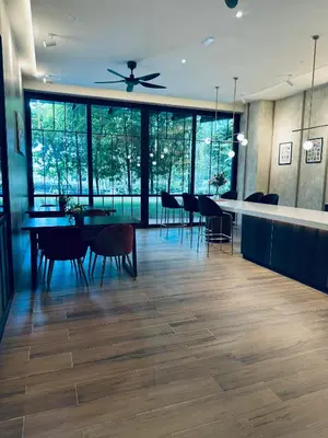 a dining room with a table and chairs and windows at Agile Premier Suites KL in Kuala Lumpur