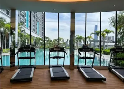 a gym with a pool in a building with glass windows at KLCC view appartment in Kuala Lumpur