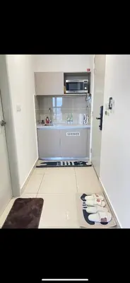 a small white kitchen with a stove top oven at KLCC view appartment in Kuala Lumpur