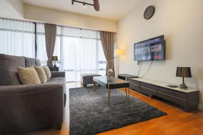 a living room with a couch and a tv at Anggun Residences Serviced Suites by GB in Kuala Lumpur