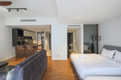 a bedroom with a large bed and a living room at Anggun Residences Serviced Suites by GB in Kuala Lumpur