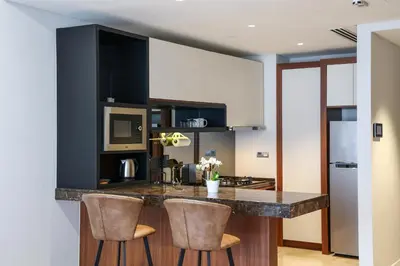 a kitchen with a counter and two stools at Anggun Residences Serviced Suites by GB in Kuala Lumpur