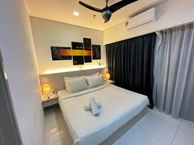 a small bedroom with a white bed with two white towels at Summer Suites klcc by kuala lumpur in Kuala Lumpur