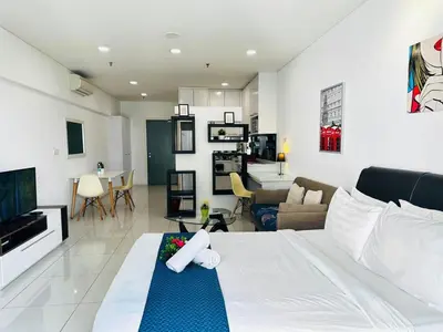 a bedroom with a bed and a living room at Summer Suites klcc by kuala lumpur in Kuala Lumpur